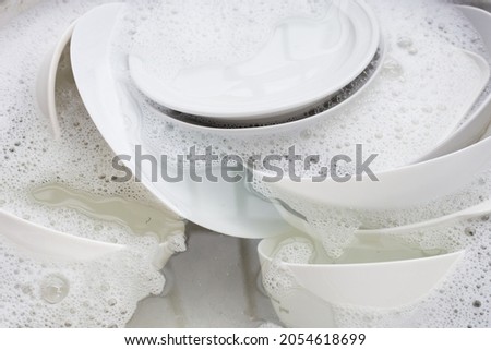 Washing dishes, Close up of utensils soaking in kitchen sink. Stock foto © 