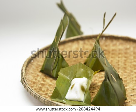Thai traditional sticky rice dessert in banana leaf packaging.