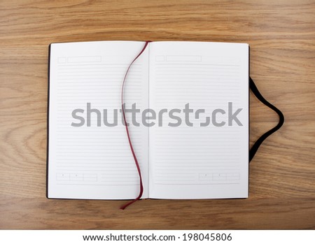 Open blank book with lines, red bookmark and black cover