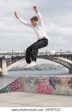 Tracer jumping in Kyiv of capital city of Ukraine. On background river Dniepr and Metro bridge
