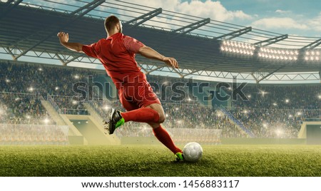 Soccer player kicks of the ball. Action. Floodlit stadium with tribunes.