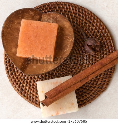 Spa set with handmade natural soap in wooden heart shape soap-dish and cinnamon stick on wicker mat