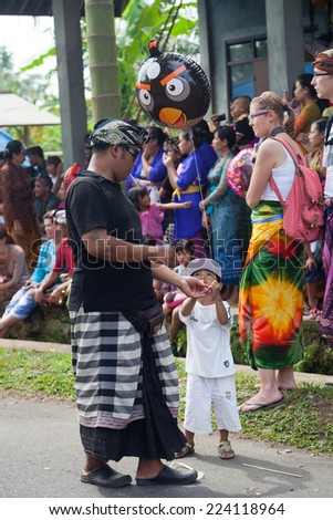 PENESTANAN, UBUD, BALI, INDONESIA - JUNE 13: Father and son with Angry birds design balloon on Ceremony of cremation - Ngaben on JUNE 13, 2013 in Penestanan village, Ubud, Bali, Indonesia
