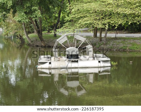 Metal water wheel floating on the lake of park