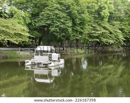 Metal water wheel floating on the lake of park