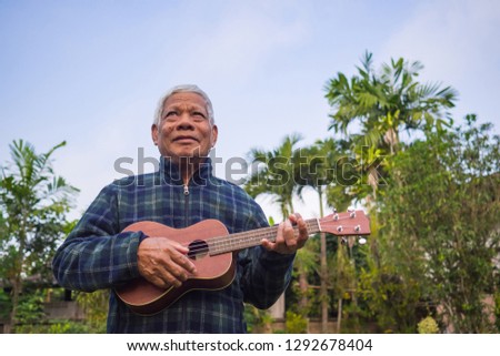 Similar – Image, Stock Photo Pensive man playing ukulele guitar