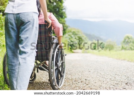 Foto Bild Eine Frau mit Behinderung geht mit ihrem Rollator, daneben ein am Boden liegender Mundschutz. Maskenpflicht um Risikopatienten zu schützen.