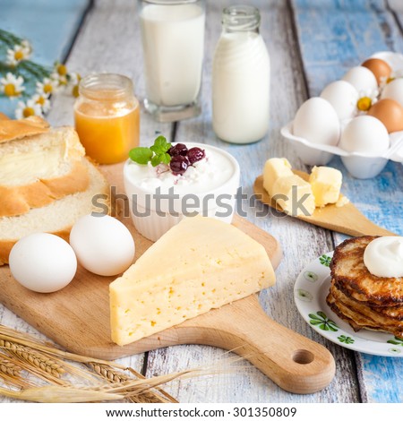Dairy products: milk, beaded cottage cheese, butter, yogurt, cheese, sour cream. With pancakes, bread, honey and fresh eggs