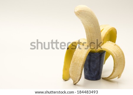 Single open banana in small pot isolated on white background