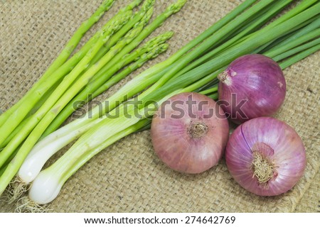 Asparagus, Onion and spring onion on sack background