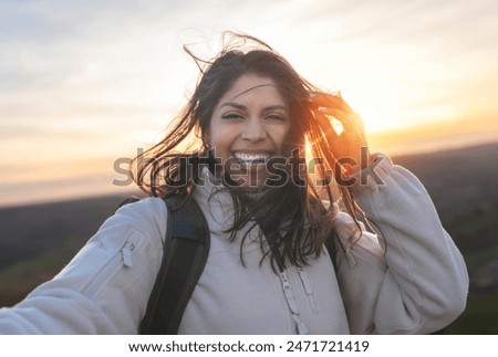 Similar – Image, Stock Photo Woman with backpack taking selfie on smartphone on background of mountains