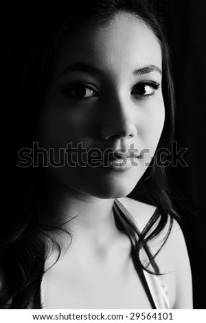 A beautiful young Indonesian model in the studio. Black and white study with soft mono-lighting.