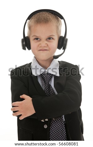 A small boy in the studio, dressed up in a suit and pretending to be a businessman, talking on a headset. Isolated on white.