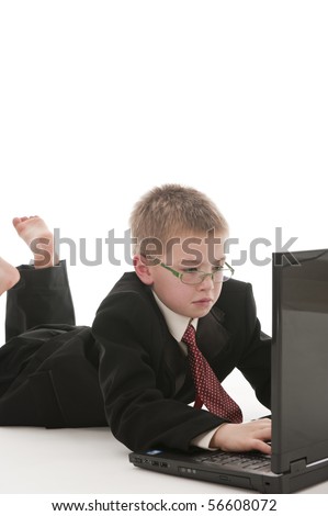 A small boy in the studio, dressed up in a suit and pretending to be a businessman.