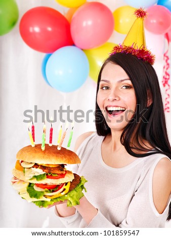 Woman eating hamburger at birthday. Isolated.