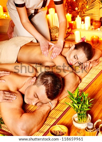 Man and woman relaxing in bamboo spa.