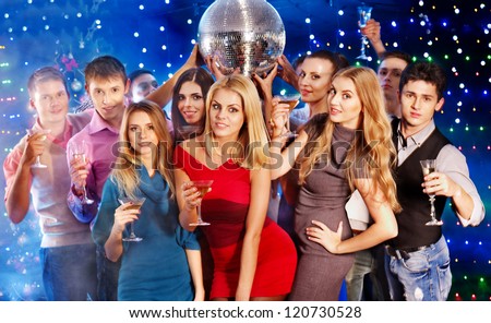Group people with  champagne dancing at party. Disco ball.