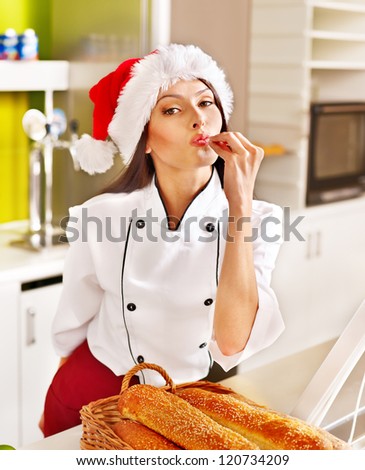 Female chef in Santa hat baking baguette bread.