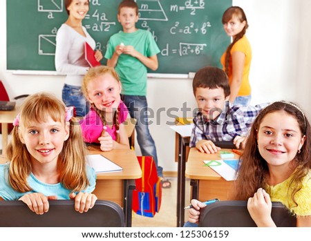 School child with teacher on math lesson.