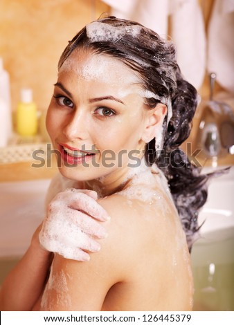 Woman washes her head at home bathroom.