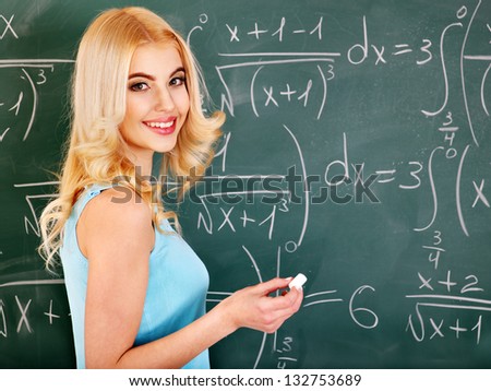 Happy schoolchild writing on blackboard.