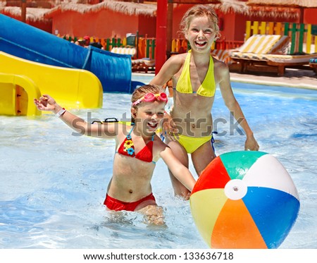 Little girl  playing ball in swimming pool.
