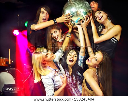 Group people on disco in night club. Lighting effects.