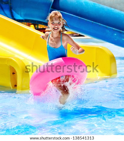 Children sitting on inflatable ring in swimming pool.