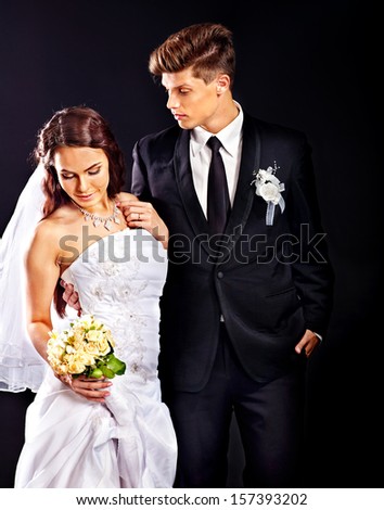 Bride and groom wearing wedding dress and costume.