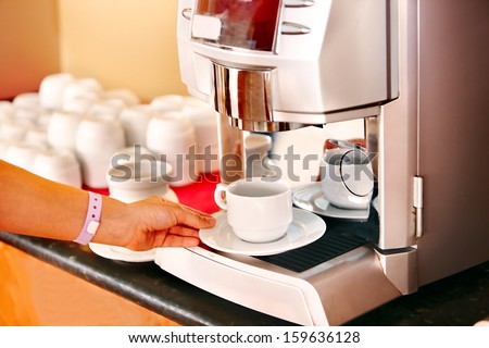 Waitresses hand with coffee machine at cafeteria .