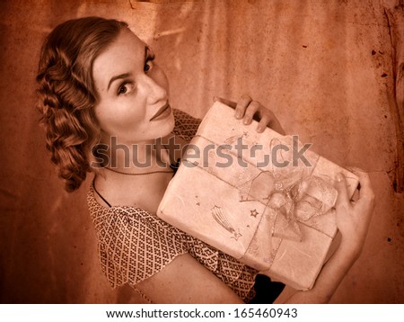 Woman holding gift box. Black and white retro.