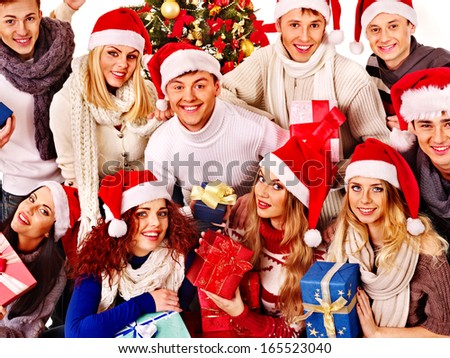 Group people and  Santa holding gift box near  Christmas tree.