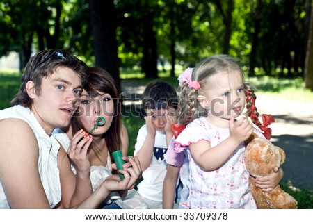 Happy family in park with soap bubbles.