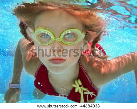 Child girl swim underwater in pool. Sport lesson.