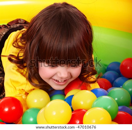 Little girl with group ball. Play room.