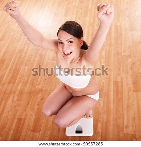 Happy beautiful girl on scales.  Weight-loss.