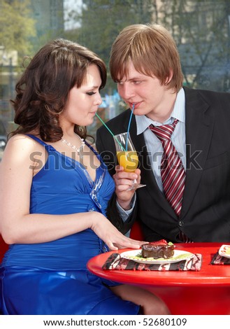 People drink orange juice in cafe. Flirting.