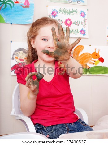 Little girl playing with clay in play room.