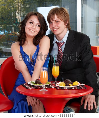 Loving couple eating cake in restaurant.