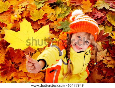 Little girl in autumn orange leaves. Outdoor.