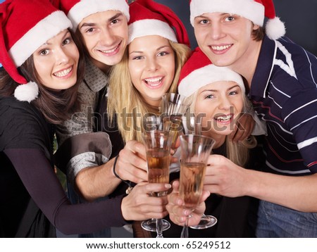 Group young people in santa hat drinking champagne at nightclub.