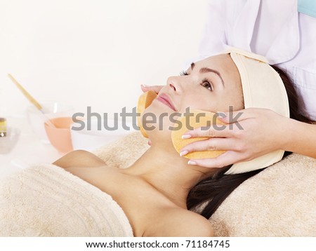 Young woman washing  face by sponge.