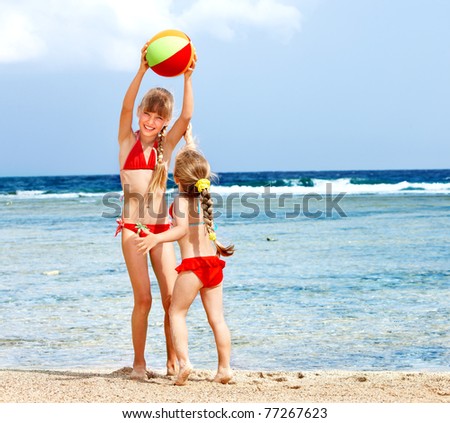 Little girl  playing on  beach with ball.