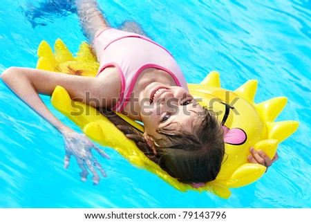 Children  on inflatable ring in swimming pool.