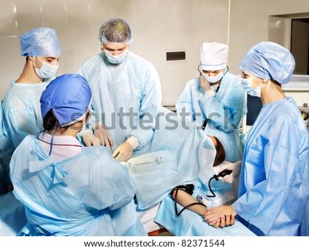 Group of surgeon looking at patient in operation room.