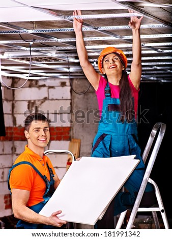 People in builder uniform installing suspended ceiling