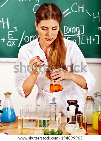 Chemistry teacher with test-tube at classroom.