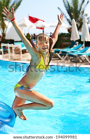 Little girl  jump in swimming  pool.