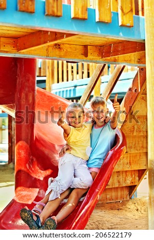 Happy children move out to slide in playground.