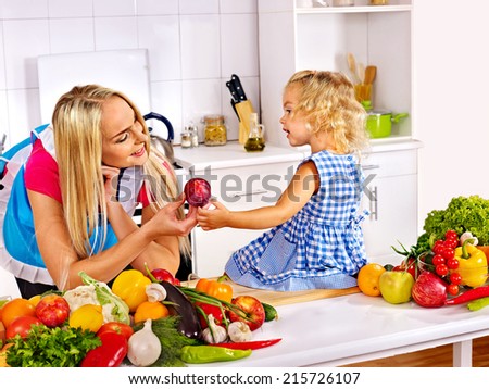 Mother and daughter prepare at kitchen.